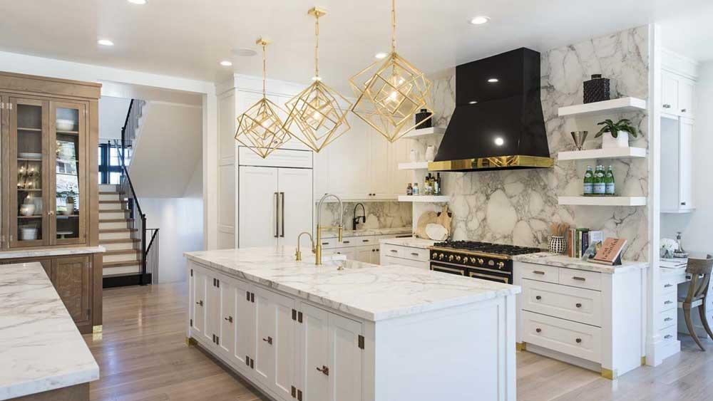 Elegant white kitchen with gold accents and marble backsplash