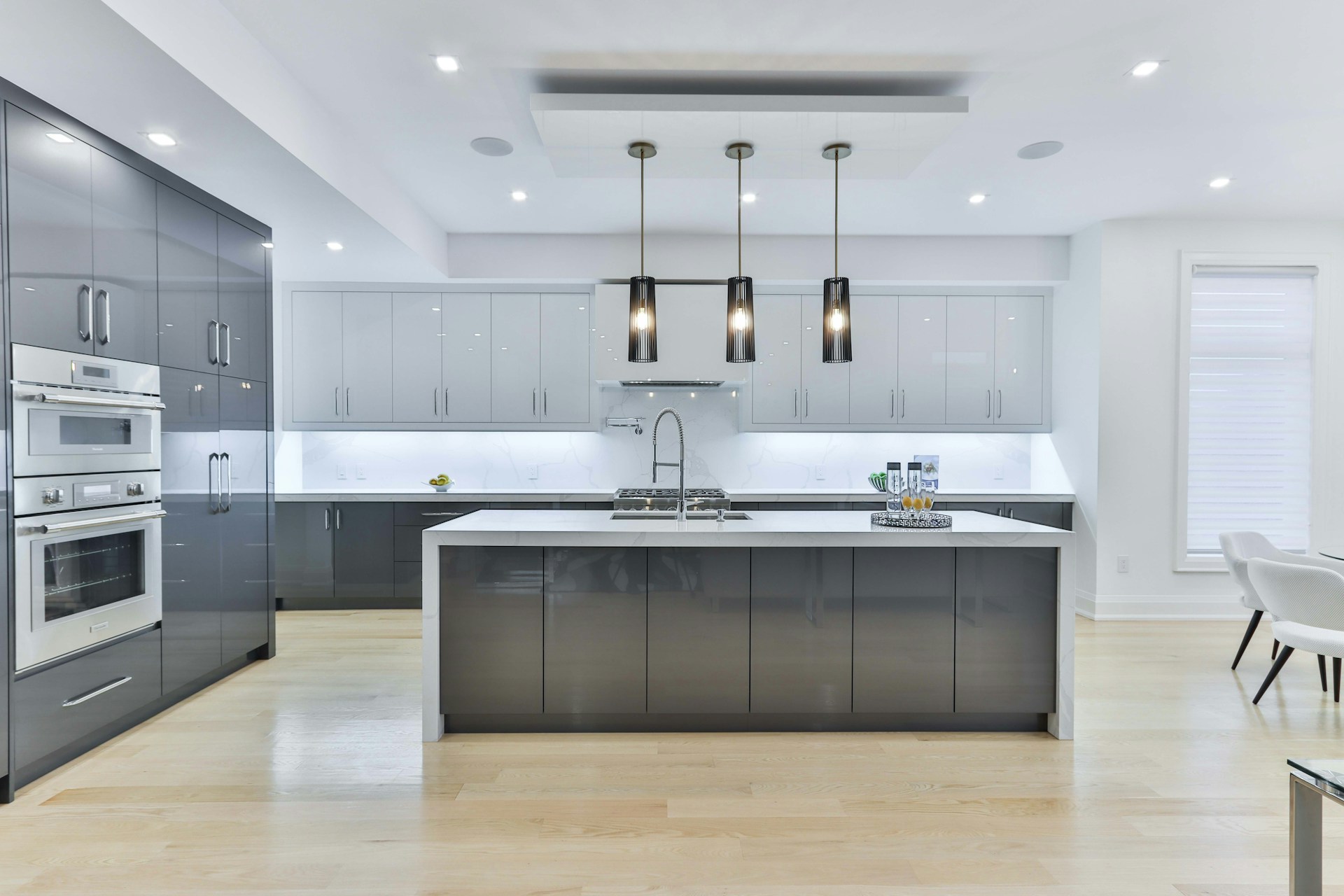 Modern sleek kitchen with gray cabinets and pendant lighting