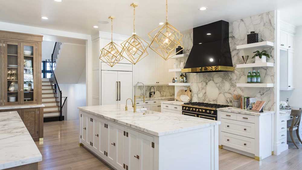 Elegant white kitchen with gold accents and marble backsplash